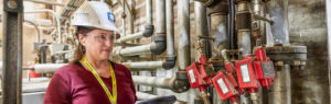 woman in hardhat looking at nuclear equipment