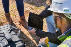 man with hardhat viewing an ipad
