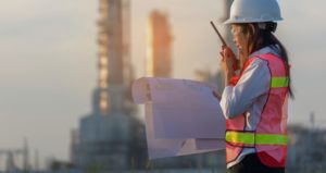 woman on site with blueprint