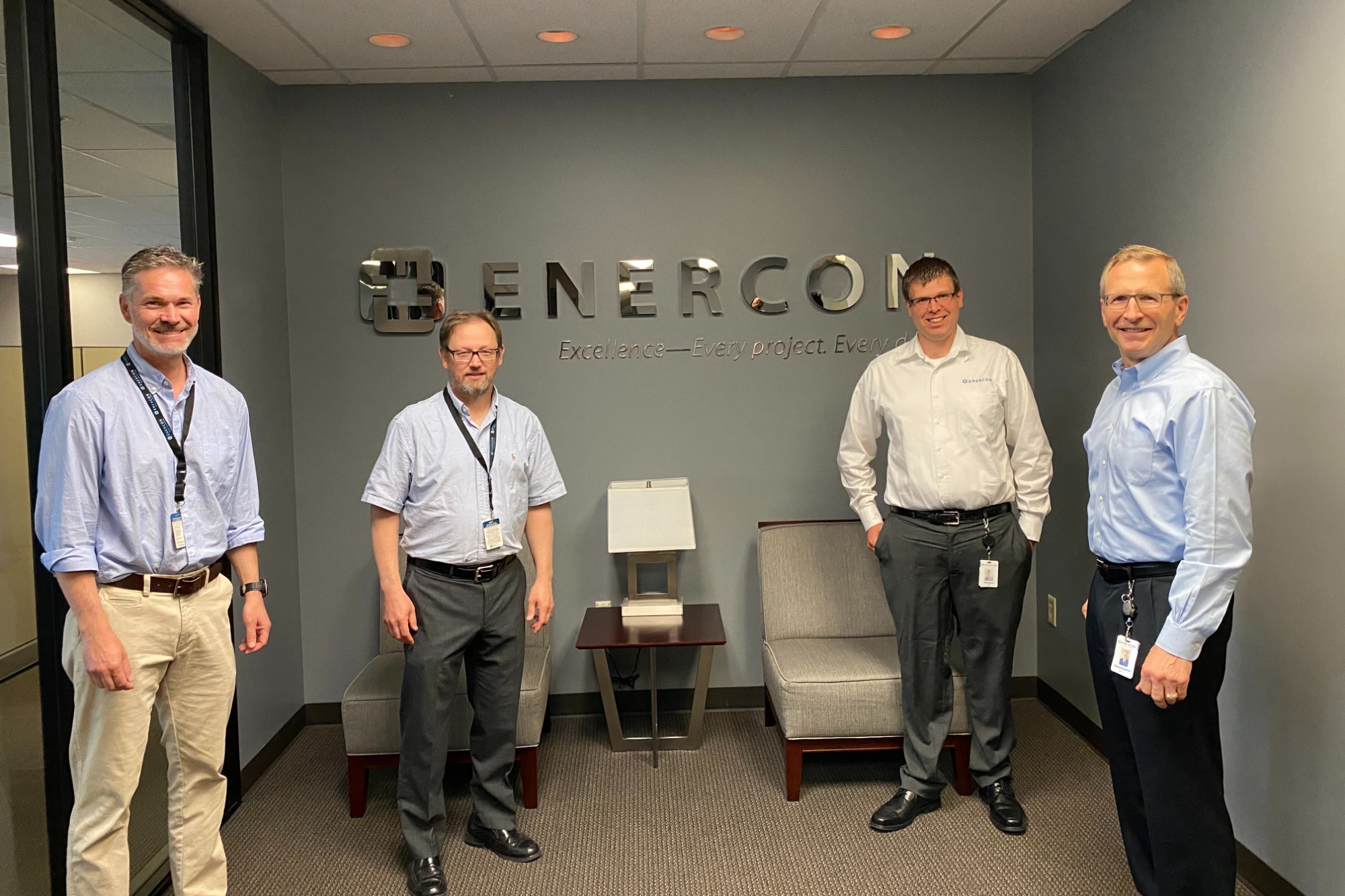 Leadership team in front of brand sign