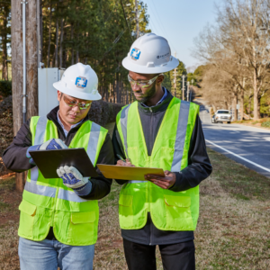 ENERCON Program Management Two engineers in hard hats looking at a tablet
